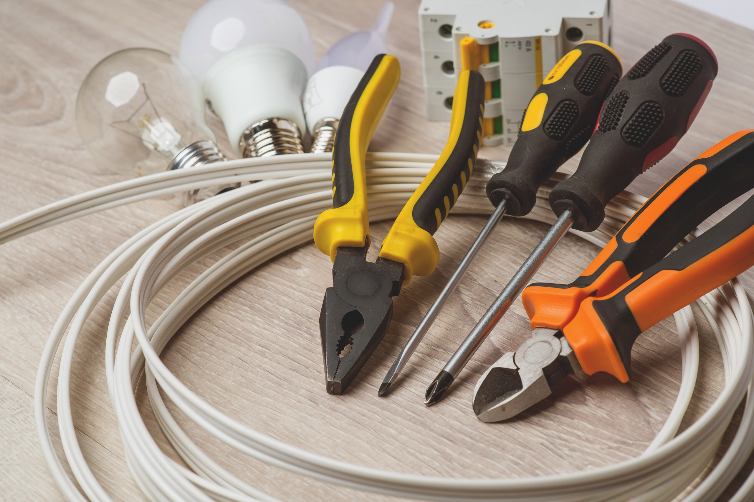 A set of tools electrician, a coil of wire and equipment on a white background